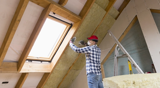 Man installing thermal roof insulation layer