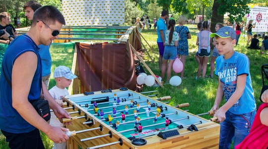Boy and his father playing foosball soccer in the park