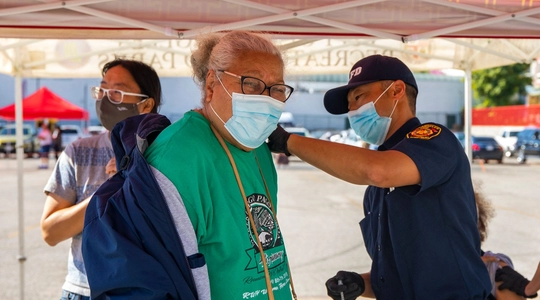 LAFD personnel administering vaccine to elderly patient