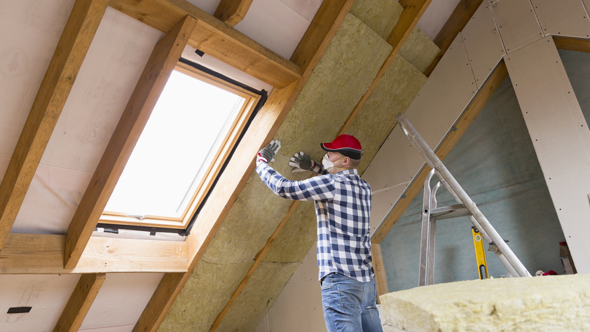 Man installing thermal roof insulation layer