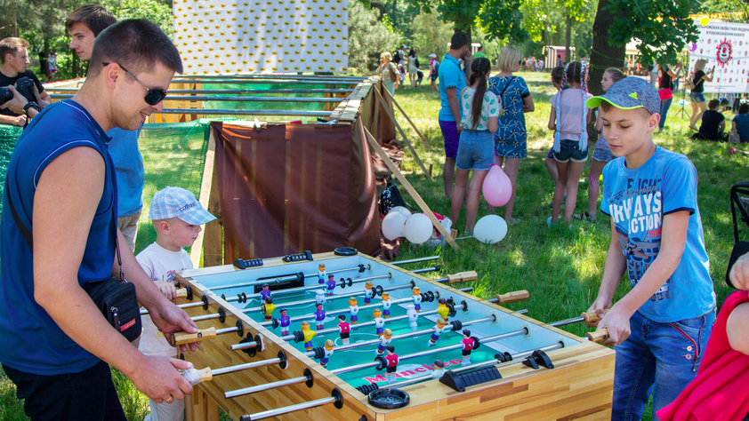 Boy and his father playing foosball soccer in the park