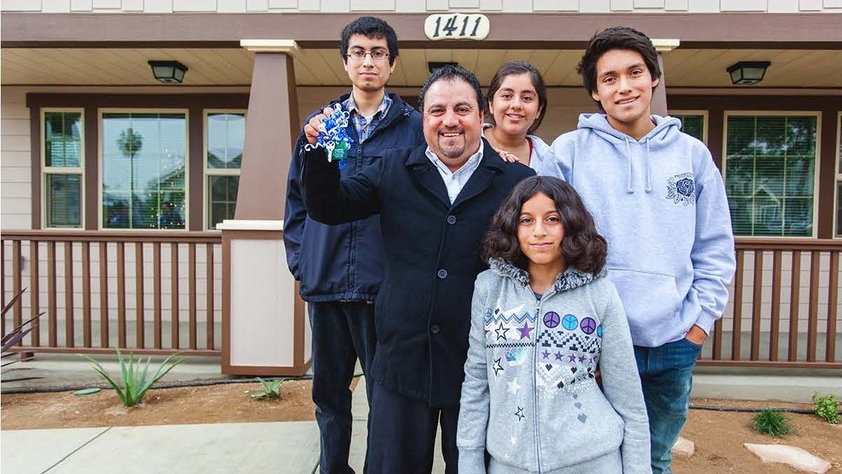 Family standing in front of a house